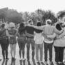 Group of multigenerational people hugging each others - Support, multiracial and diversity concept - Main focus on center people - Black and white editing