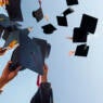 People Throwing Mortarboards Against Clear Sky